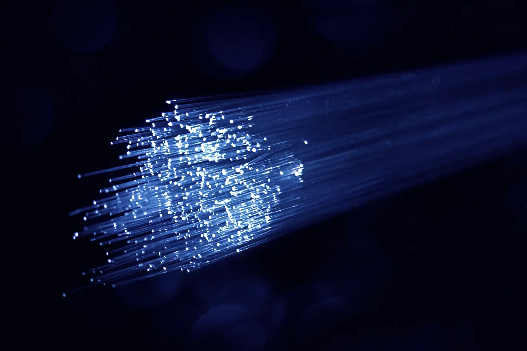 Strands of blue fibre-optic light against a dark background