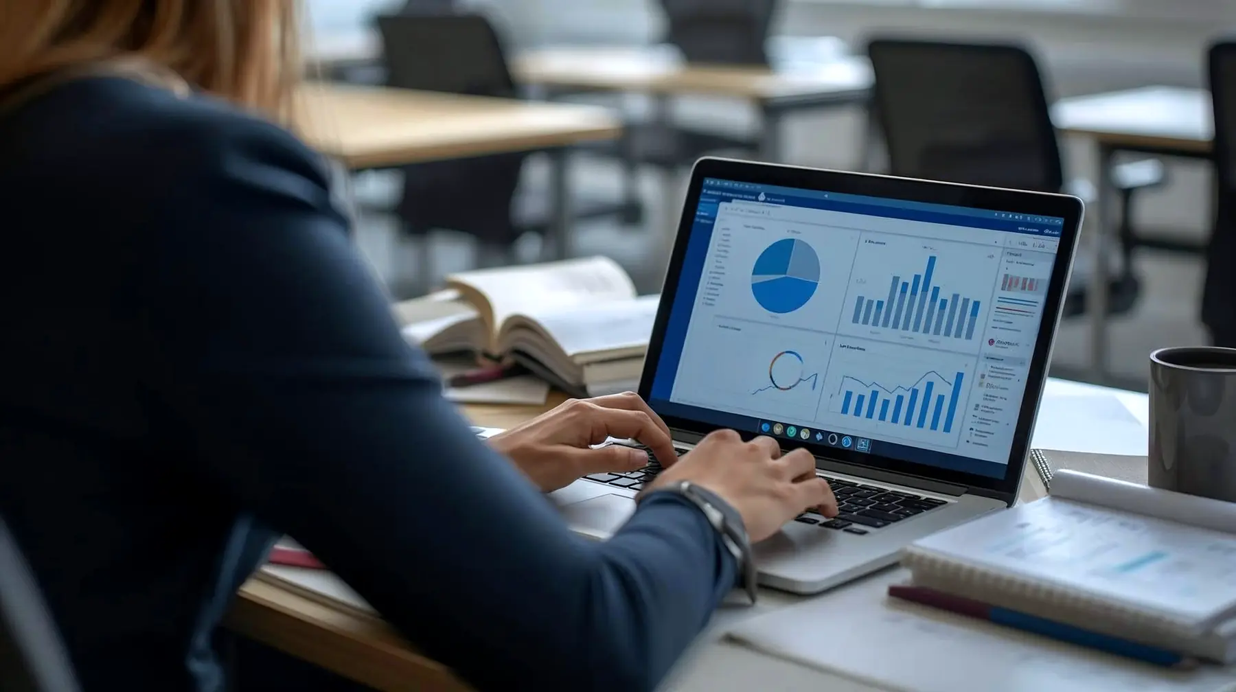 An analyst working through charts and dashboards on a laptop