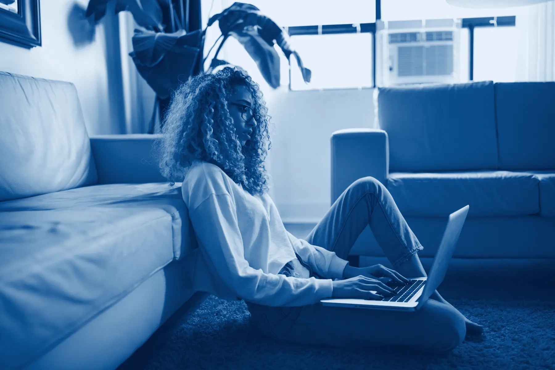 A person working through questions on a laptop in a bright room, in Capdeva navy