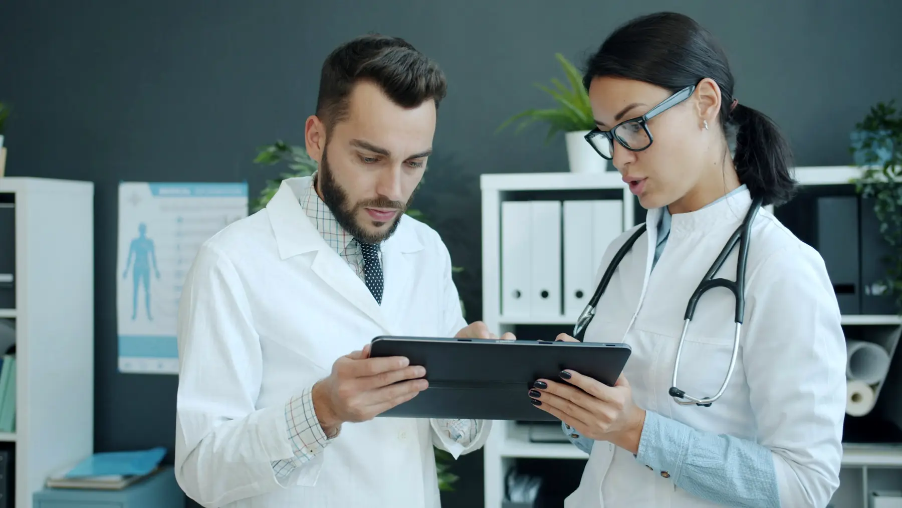 Two clinicians reviewing patient information on a tablet