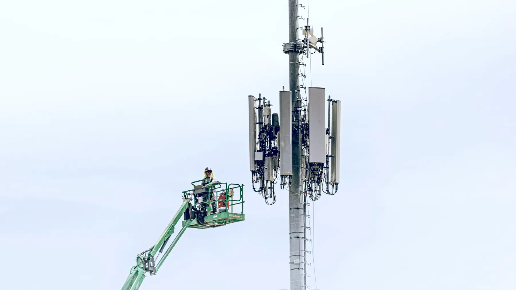 An engineer on a lift servicing equipment on a cell tower