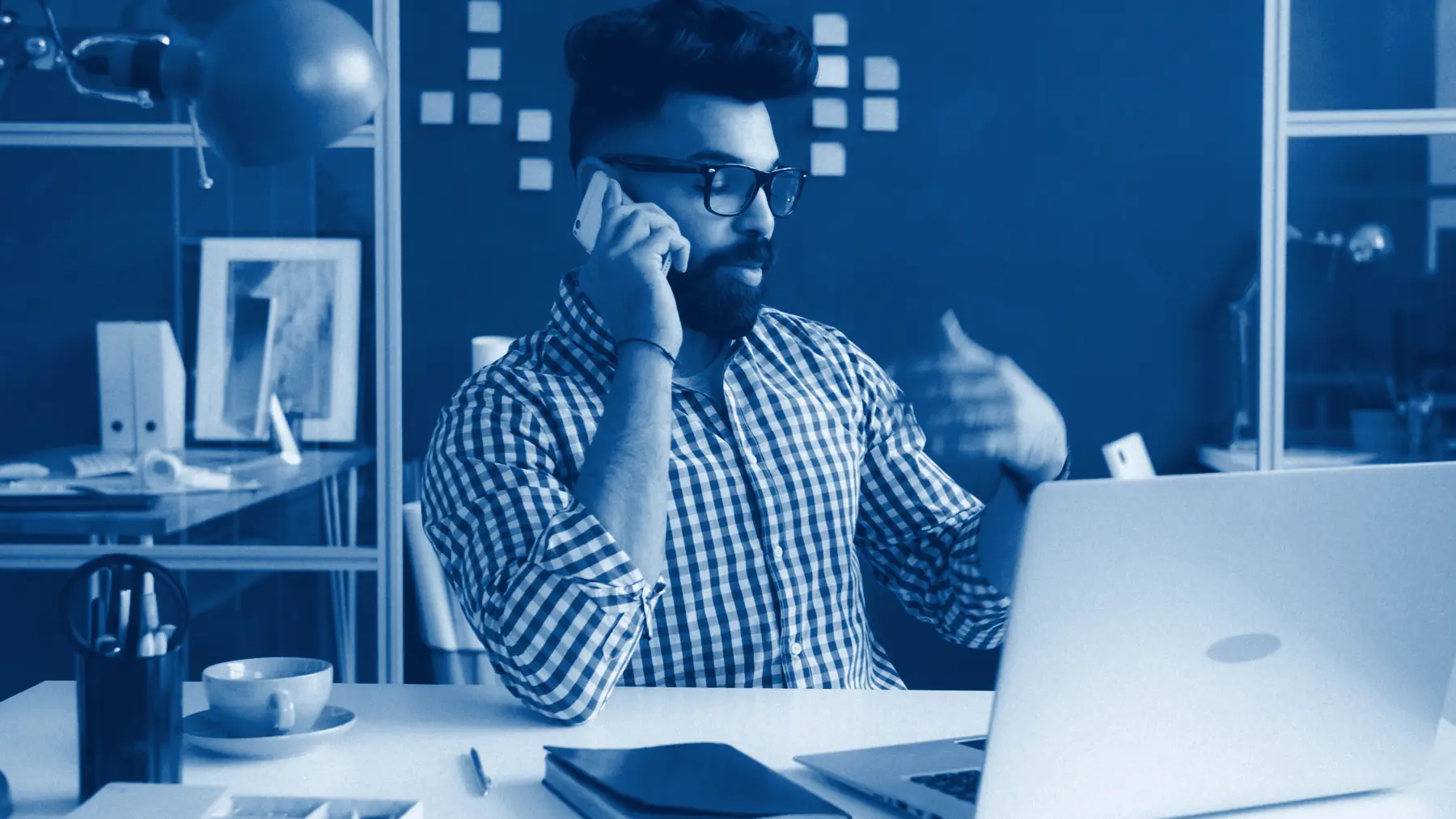 A recruiter mid-conversation on a phone call at his desk
